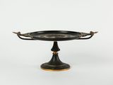 an image of a black and gold plate on a stand