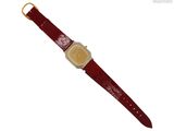 un gros plan d'une montre-bracelet avec un bracelet en cuir rouge