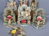 cinq figurines représentant des personnes dans un jardin, ornées de fleurs