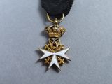 a close up of a medal on a black ribbon with a crown
