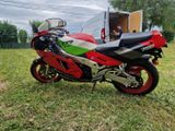 a red and green motorcycle parked in the grass