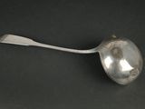 une cuillère en argent dont le manche repose sur une surface noire