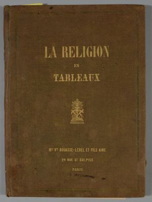 un vieux livre posé sur une table à côté d'un mur blanc