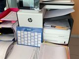 a desk with a lot of papers and a printer on it
