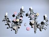 two wall sconces with flowers and leaves on them