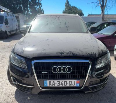 a black audi parked in a parking lot next to other cars