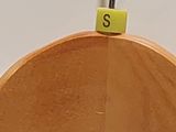 a wooden hanger that has a yellow letter s on it