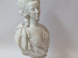 a white bust of a woman with a tia on her head