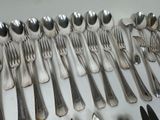 many spoons and forks laid out on the table