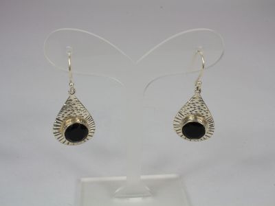a pair of silver earrings with black stones on them