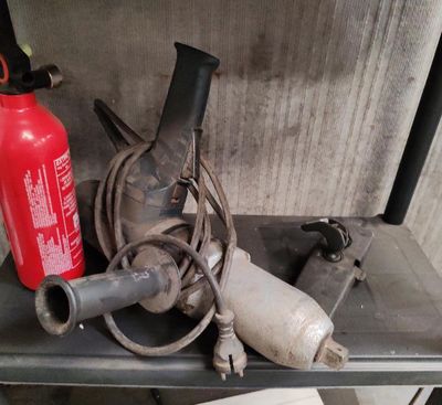 un extincteur et une lance à incendie posés sur une étagère