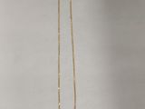 un gros plan d'un collier en or auquel est accrochée une étiquette