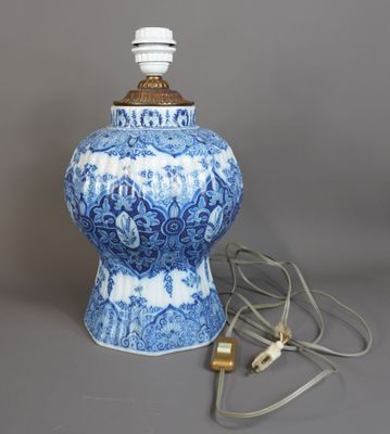 un vase bleu et blanc sur lequel est posée une lampe