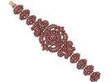 un gros plan d'un bracelet avec des perles rouges sur fond blanc