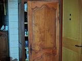 a cabinet in the corner of a room with a door open