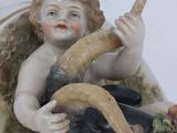 a figurine of an angel sitting on a goat