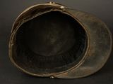 an old leather hat on a black surface with a black background