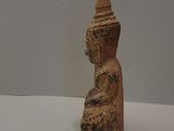 a small statue of a person sitting on a white surface