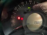 dashboard of a car with a speedometer and a hand holding a steering wheel