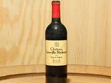 une bouteille de vin posée sur un tonneau