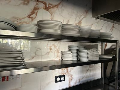 de nombreuses assiettes et casseroles empilées sur une étagère dans une cuisine