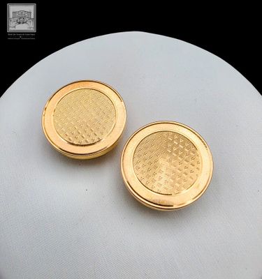 une paire de boutons de manchette dorés, montés sur un collier blanc de type « mannequin »