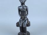 l'image d'une statue d'un homme assis sur une chaise