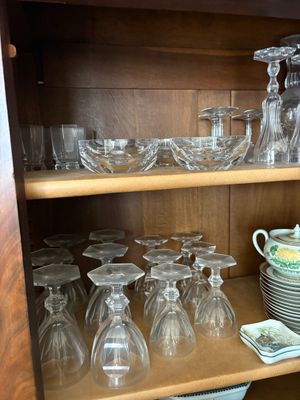 de nombreux verres et assiettes rangés sur une étagère dans un placard