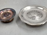 a silver plate and a silver cup on a table