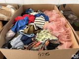 a cardboard box filled with lots of assorted clothing