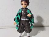 figurine d'anime représentant un jeune homme vêtu d'une tenue verte et noire