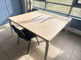 a table with a laptop on it in front of a window