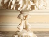 a white marble pedestal with a bird on top of it