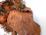 un gros plan d'une sculpture représentant un chien avec des fleurs sur la tête