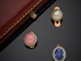 deux paires de boucles d'oreilles et une bague posées sur un fond noir