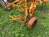 a tractor with a plow attached to it in the grass