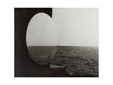 black and white photograph of a view of the ocean through a round window