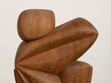 sculptures made of wood sit on a white pedestal against a white background