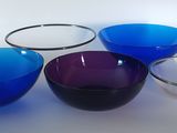 quatre bols de couleurs différentes posés sur une table blanche