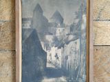an old photo of a street in a village with a building in the background