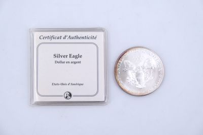 a silver eagle next to a quarter of a coin