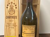 une bouteille de vin à côté d'une caisse en bois sur une table