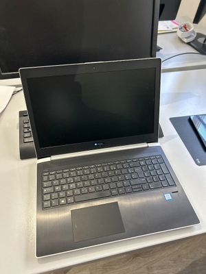 un ordinateur portable posé sur un bureau blanc