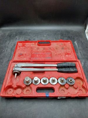 une mallette à outils rouge contenant une clé et des écrous