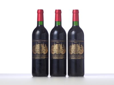 three bottles of red wine sitting on top of a table