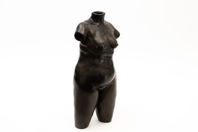 a statue of a woman that is standing on a white surface