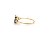a close up of a gold ring with a black diamond