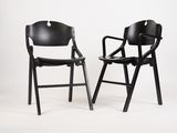 une paire de chaises pliantes noires sur fond blanc