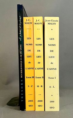 trois livres posés l'un à côté de l'autre sur une table