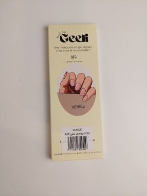 un gros plan d'une boîte de vernis à ongles posée sur une surface blanche